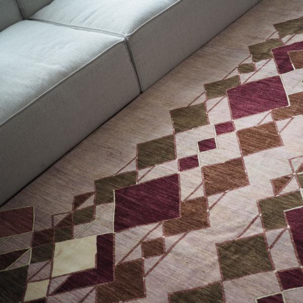 La diseñadora está sentada en una alfombra bereber con un patrón gráfico de zigzag en blanco y negro